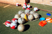 Soccer balls and equipment on a soccer field.