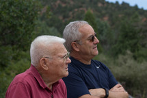 side profile of men standing together outdoors 