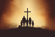 Silhouette of a family standing in front of the cross