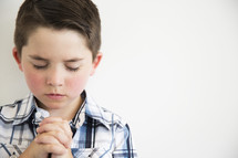 a little boy in prayer.