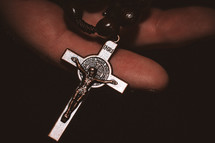 Rosary of Jesus Christ in old dirty and rough working hands praying to God.