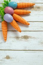 Easter eggs and carrots on wood background 