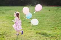 girl child running with balloons 