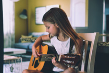 a girl playing a guitar 