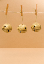 gold bells hanging from clothespins 
