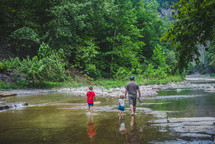 family walking in a stream bed 