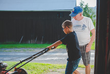 grandfather and grandson working on a lawnmower 