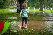 toddler playing in a puddle 