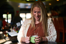 a woman holding a green coffee cup 