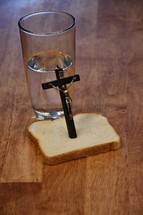 crucifix and bread and water on a kitchen table 