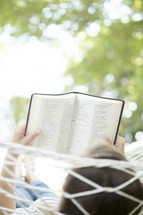 woman reading a Bible in a hammock 