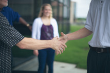 welcoming hand shakes by church greeters 