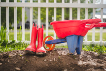 red rain boots and toy wheelbarrow 