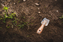handheld shovel in dirt 