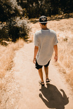 a man walking on a dirt path 