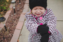 toddler girl bundled up for chilly weather crying 