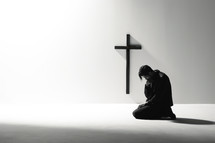 Man praying in front of a cross with copy space