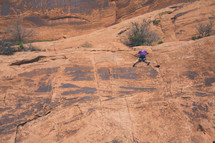 a man rock climbing a steep cliff 