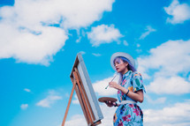 a woman painting outdoors 