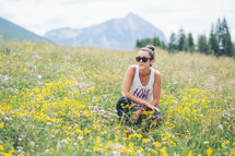 woman squatting in a field of wildflowers 