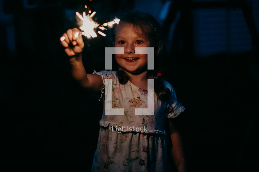 child playing with sparklers on the 4th of July