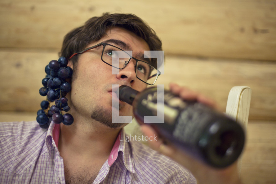 Man Grapes Behind Ear Drinks wine