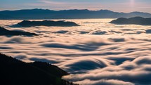 Wave of foggy clouds motion fast in forest mountains in sunny spring morning nature Time-lapse
