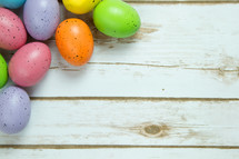 speckled Easter eggs on white wood boards 