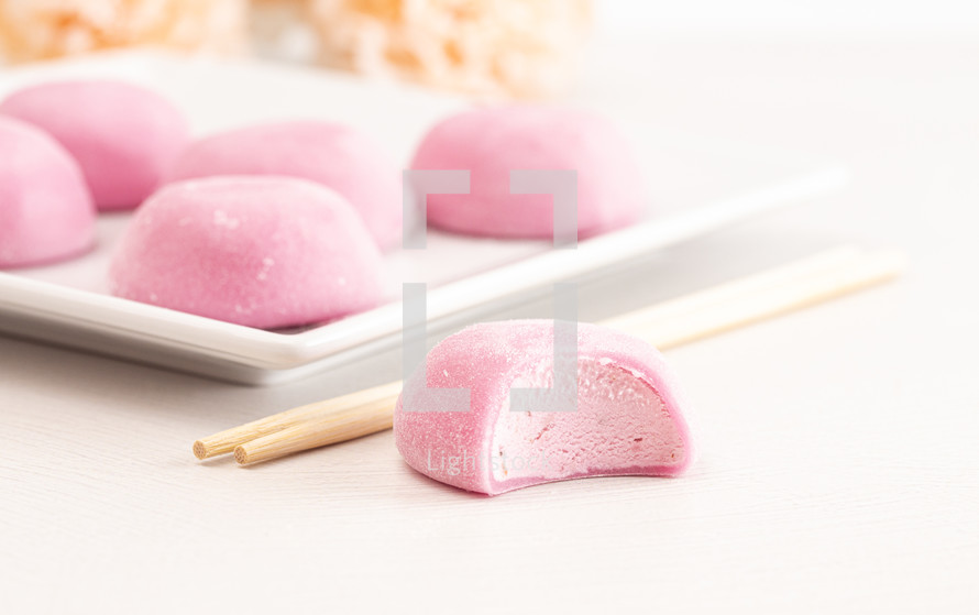 Pink Mochi Ice Cream with a Rose Flower on a White Table