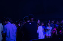 teens praying over each other at a youth rally