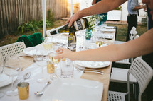 pouring wine at a dinner party 