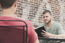 men reading a Bible during a Bible study outdoors