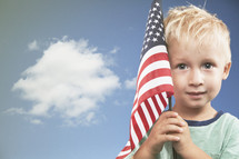 little boy holding an American flag