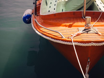 an orange boat tied to a dock