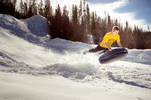 s man tubing in the snow 
