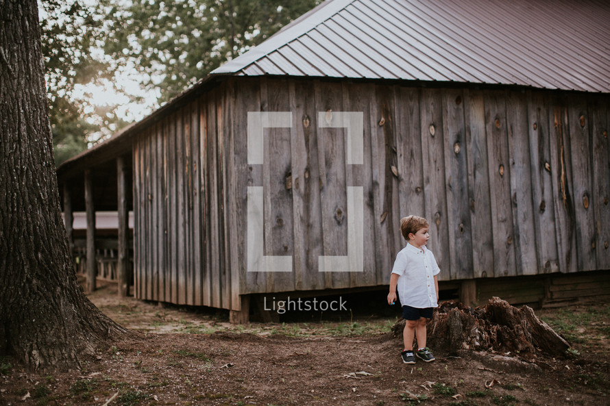 toddler boy in front of a cabin 