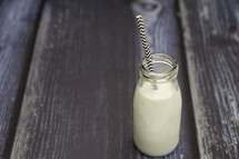 milk in a glass bottle with a straw 