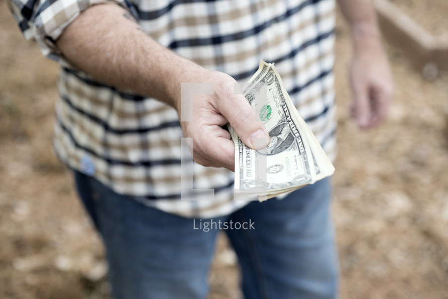 a man holding out cash 