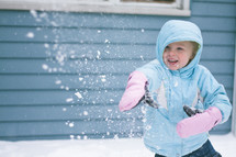 girl child throwing snowballs 