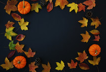 fall leaves and pumpkins on a black background 