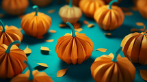 Paper machete pumpkins on a teal background. 