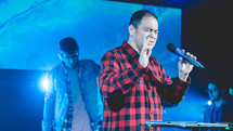 men holding microphones singing during a worship service 