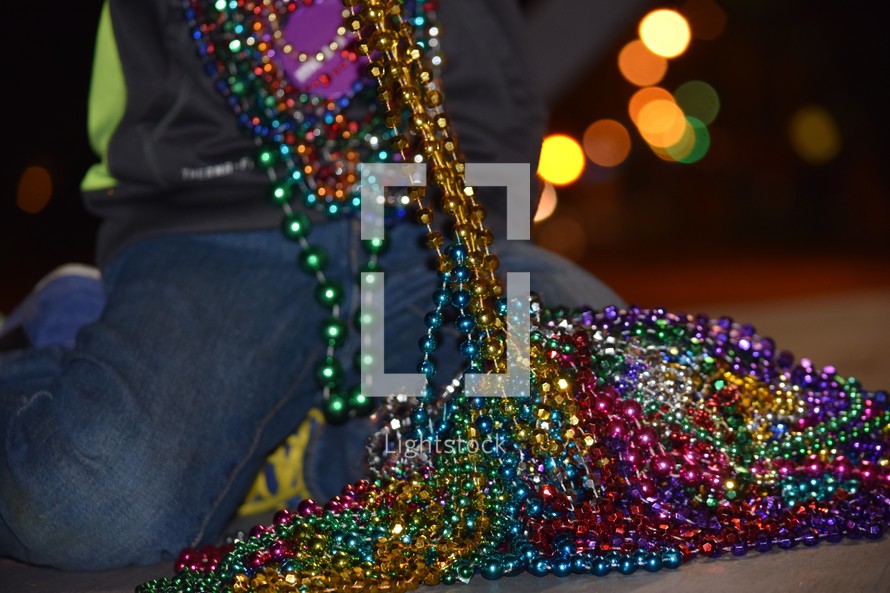 A little boy counting his beads after a Mardi Gras Parade 