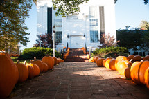 pumpkins lining a sidewalk to a church 