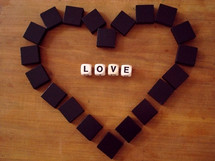 Letter blocks spelling out "love" surrounded by a heart of blocks.