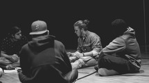 men sitting on the floor in a discussion 