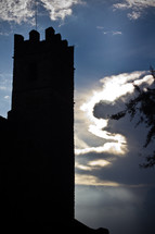 clouds peeking behind a castle tower