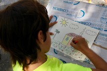 a child coloring a house drawing 