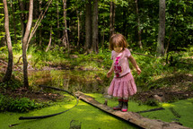 little girl exploring a pond 