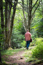 man walking on a path in a forest 
